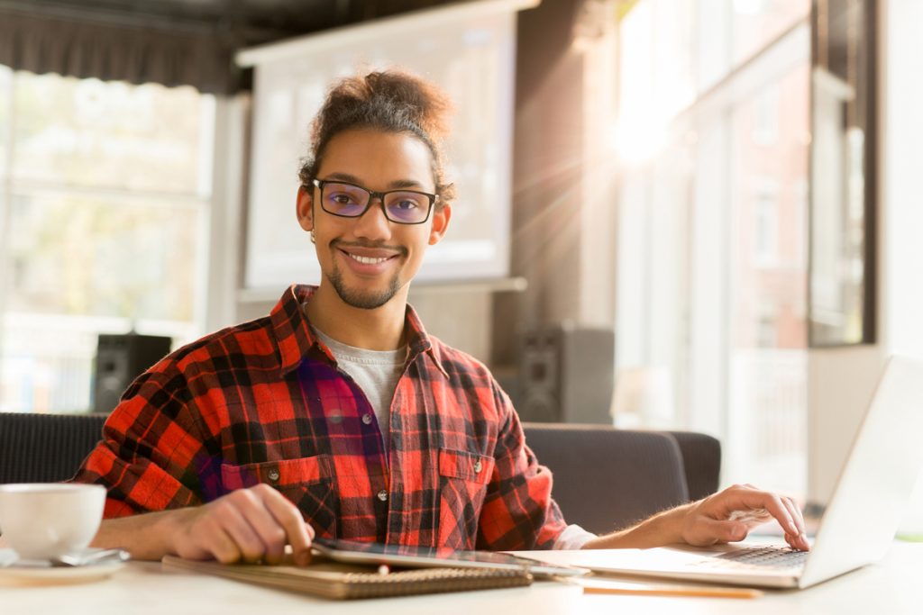 Young manager with laptop searching for online statistics for his business project.