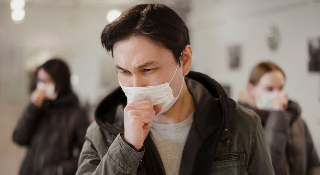 Front view of people with medical masks coughing.