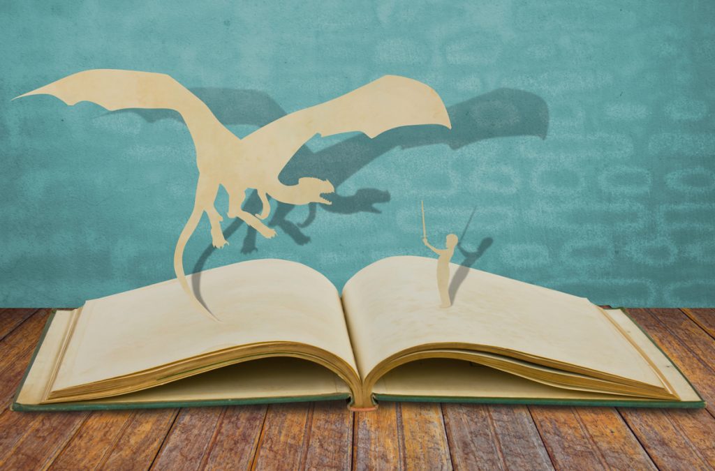 Paper cut of dragon and child hold sword on old book.